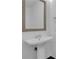 A bathroom with a pedestal sink, framed mirror, and modern fixtures at 1080 Peachtree Ne St # 2003, Atlanta, GA 30309