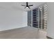 A bright bedroom with hardwood floors, a ceiling fan, and a large window with city views at 1080 Peachtree Ne St # 2003, Atlanta, GA 30309