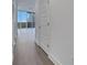 Bright hallway features wood floors, white walls, and a view of the city through the windows at the end of the hall at 1080 Peachtree Ne St # 2003, Atlanta, GA 30309