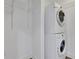 Laundry area includes stacked washer and dryer units, shelving for storage, and light gray floors at 1080 Peachtree Ne St # 2003, Atlanta, GA 30309