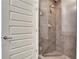 A modern shower with gray tile, a glass enclosure, and a white door providing access at 1080 Peachtree Ne St # 2003, Atlanta, GA 30309