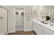 Bright bathroom with double vanity, shower, and closet for storage with decorative artwork on the walls at 1216 Arnhem Dr, Hampton, GA 30228