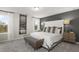 Bedroom featuring a neutral palette with a gray accent wall, two large windows and a stylish upholstered bench at 1216 Arnhem Dr, Hampton, GA 30228