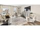 Open-concept living room featuring stylish decor, a television, plush seating, and a coffee table at 1216 Arnhem Dr, Hampton, GA 30228