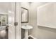 Stylish powder room featuring a pedestal sink, decorative mirror, and modern decor at 1216 Arnhem Dr, Hampton, GA 30228