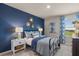 Stylish bedroom with a blue accent wall, coordinated linens, and plenty of natural light at 1220 Arnhem Dr, Hampton, GA 30228