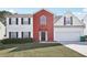 Charming two-story home featuring a red brick facade, white siding, and a well-manicured lawn at 1618 Blossom Dr, Atlanta, GA 30349