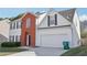 A lovely home with brick and siding, offering a two-car garage, driveway, and trash can at 1618 Blossom Dr, Atlanta, GA 30349