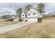 Angle view of a charming two-story home with white siding, a brick entryway, attached two-car garage, and landscaped front yard at 71 Farm St, Hiram, GA 30141