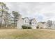 Angle view of a charming two-story home with white siding, a brick entryway, attached two-car garage, and landscaped front yard at 71 Farm St, Hiram, GA 30141