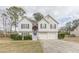 Charming two-story home with white siding, a brick entryway, attached two-car garage, and landscaped front yard at 71 Farm St, Hiram, GA 30141