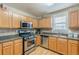 Functional kitchen featuring stainless steel appliances, oak cabinets, and granite countertops at 71 Farm St, Hiram, GA 30141