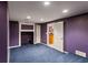 Basement bonus room with purple walls, blue carpet and open doorway to kitchenette at 727 Vinings Estates Se Dr, Mableton, GA 30126