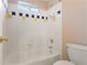 Bathroom showcasing a tiled tub and shower with blue and yellow accent tiles at 727 Vinings Estates Se Dr, Mableton, GA 30126