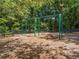 A classic swing set in a community park setting with benches and shade trees at 727 Vinings Estates Se Dr, Mableton, GA 30126