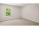 A minimalist bedroom with neutral carpet and a large window offering a view of the outside at 13224 Tolstoy, Covington, GA 30014