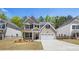 Charming two-story home with brick and gray siding, a manicured lawn, and a two-car garage at 13224 Tolstoy, Covington, GA 30014