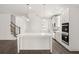 Open-concept kitchen with stainless steel appliances, hardwood floors and white center island at 13224 Tolstoy, Covington, GA 30014