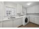 Bright laundry room with white cabinetry, modern washer/dryer, and a convenient sink area at 3814 Vermont Ne Rd, Atlanta, GA 30319