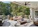 Relaxing covered patio with stone floors, ceiling fan, outdoor grill, and comfortable seating area surrounded by trees at 3814 Vermont Ne Rd, Atlanta, GA 30319