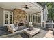 Cozy covered patio featuring a stone fireplace, comfortable seating, and an outdoor grill, perfect for entertaining at 3814 Vermont Ne Rd, Atlanta, GA 30319