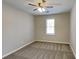 This bedroom offers neutral walls and carpet and a modern ceiling fan with lights at 4614 Blakedale Cir, Roswell, GA 30075