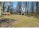 A partially fenced backyard features a storage building near the home and mature shade trees at 832 Toonigh Rd, Canton, GA 30115