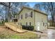 Side view of a two-story house with a wooden ramp, wood siding, and a well-maintained landscape at 832 Toonigh Rd, Canton, GA 30115