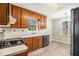 Functional kitchen with wooden cabinets, black appliances, laminate floors, and bright lighting at 832 Toonigh Rd, Canton, GA 30115