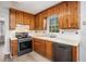 Efficient kitchen featuring wooden cabinets, sleek black appliances, and durable laminate flooring at 832 Toonigh Rd, Canton, GA 30115