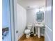 Modern half bathroom with a pedestal sink, toilet, and decorative mirror at 361 Watson Ave, Woodstock, GA 30189