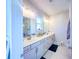 Bathroom with double vanity, white cabinets, tile flooring and ample light from the window at 361 Watson Ave, Woodstock, GA 30189