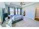 Bright bedroom featuring a ceiling fan, tray ceiling, and large windows that provides natural light at 361 Watson Ave, Woodstock, GA 30189