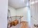 Hallway with hardwood floors, wooden banister and a brown leather bench on a decorative rug at 361 Watson Ave, Woodstock, GA 30189