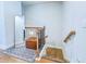 A staircase landing with a mirror, a brown ottoman, and a rug on the wooden floor at 361 Watson Ave, Woodstock, GA 30189