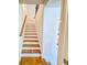 Carpeted staircase with a wood handrail, offering a seamless transition between floors at 361 Watson Ave, Woodstock, GA 30189