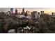 City skyline view behind a modern home surrounded by bare trees in an aerial real estate shot at 79 Beverly Ne Rd, Atlanta, GA 30309