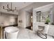 Bright bathroom features a soaking tub, marble floors, vanity, and bronze chandelier at 79 Beverly Ne Rd, Atlanta, GA 30309