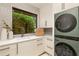 Bright laundry room with modern appliances, stylish cabinetry, and a garden view at 79 Beverly Ne Rd, Atlanta, GA 30309