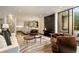 Living room with white couch and stone accent wall. Connected is an open kitchen with marble island and hardwood floors at 79 Beverly Ne Rd, Atlanta, GA 30309