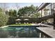 A modern backyard with a dark swimming pool, lounge chairs, umbrellas, and beautiful greenery at 79 Beverly Ne Rd, Atlanta, GA 30309