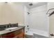This bathroom offers a tub with white tile surround, a dark granite counter and updated fixtures at 1106 Hampton Ne Way, Atlanta, GA 30324