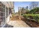 Side exterior view showing a large patio area with established garden beds at 1106 Hampton Ne Way, Atlanta, GA 30324