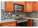 Close-up view of a kitchen with stainless steel oven, mosaic backsplash, and granite counters at 1106 Hampton Ne Way, Atlanta, GA 30324
