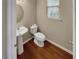 This half-bathroom features a pedestal sink, toilet, and hardwood floors at 265 Edinburgh Ln, Woodstock, GA 30188