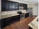 Modern kitchen featuring stainless steel appliances, granite countertops, and dark cabinetry at 265 Edinburgh Ln, Woodstock, GA 30188