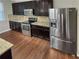 Spacious kitchen features stainless steel appliances, granite countertops, and plenty of dark wood cabinets for storage at 265 Edinburgh Ln, Woodstock, GA 30188