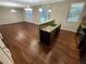 Open concept kitchen island with sink and stainless steel appliances that flows into the living room at 265 Edinburgh Ln, Woodstock, GA 30188