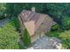 Overhead view of the home featuring a brick exterior, attached garage, long driveway, and mature trees at 403 Glenhurst Trce, Canton, GA 30115