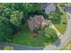 Aerial shot of a lush green lot with mature trees surrounding the two-story brick home and driveway at 403 Glenhurst Trce, Canton, GA 30115
